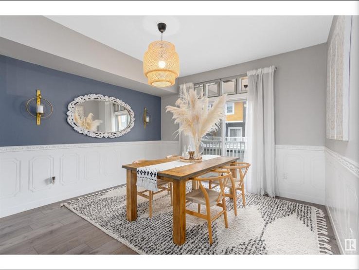 Dining room with blue accent wall, oval mirror and pampas