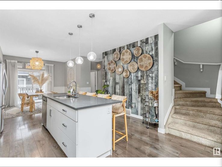 Kitchen island view toward stair and reclaimed-wood feature wall