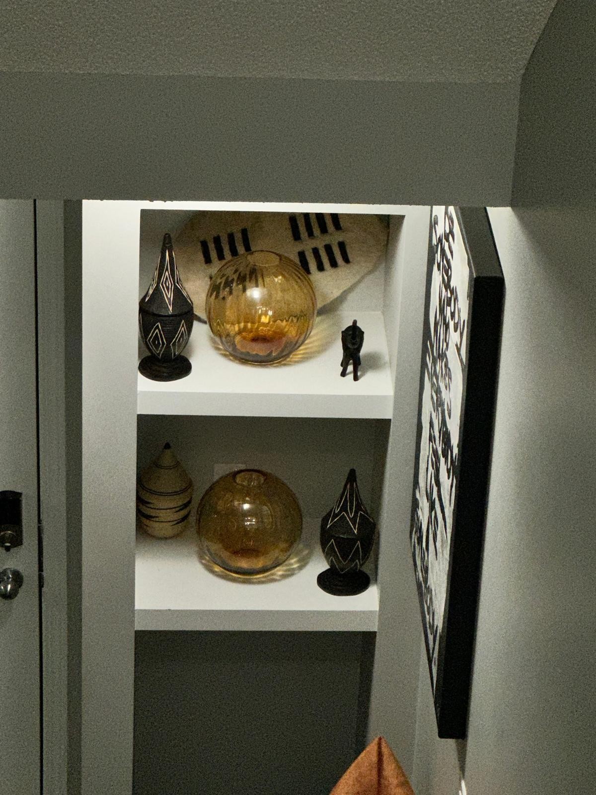 Curated shelf vignette with amber glass and hand-carved vessels by Gratia Design Studio