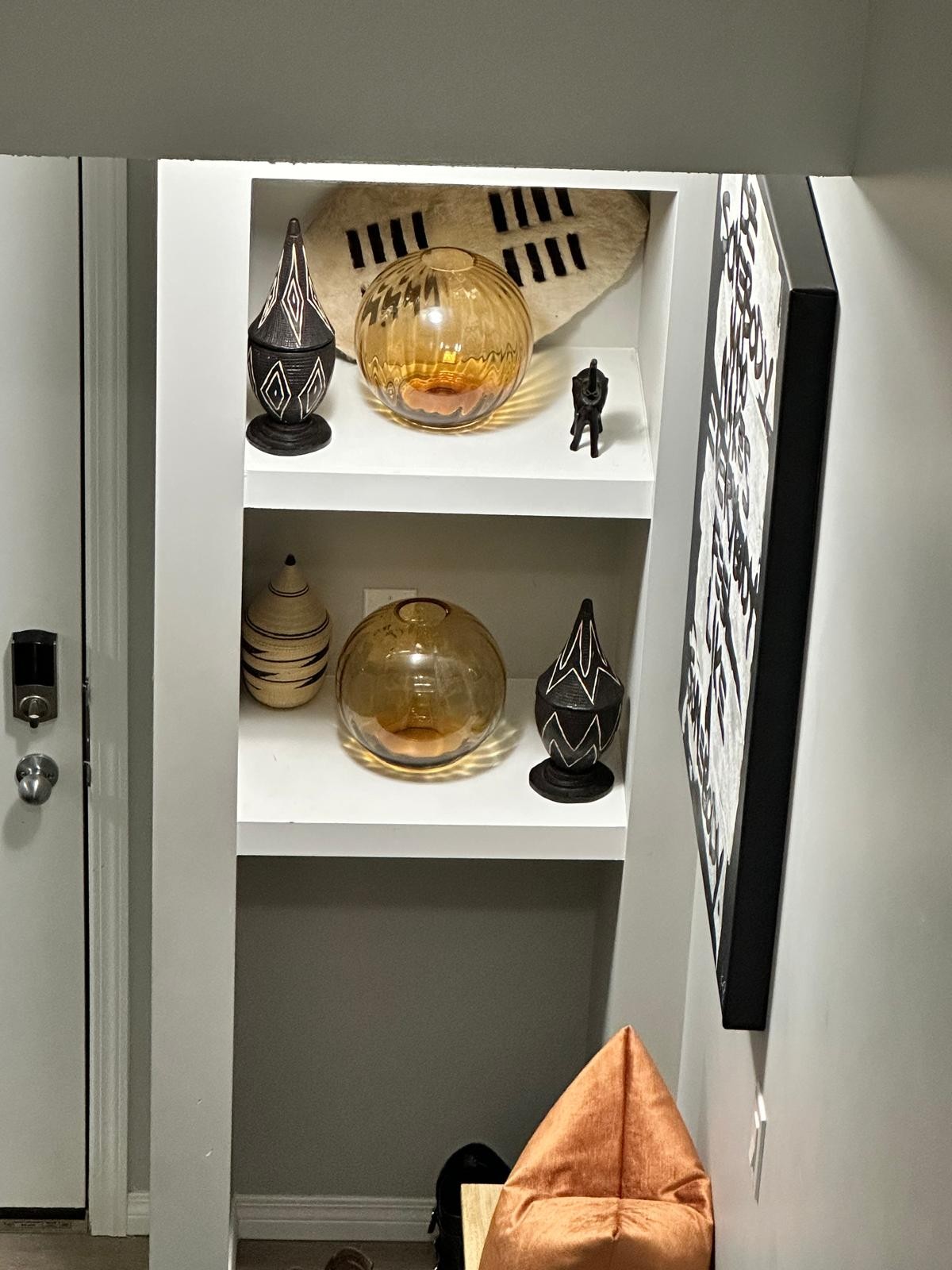 Wider view of curated shelf vignette beside the front entry