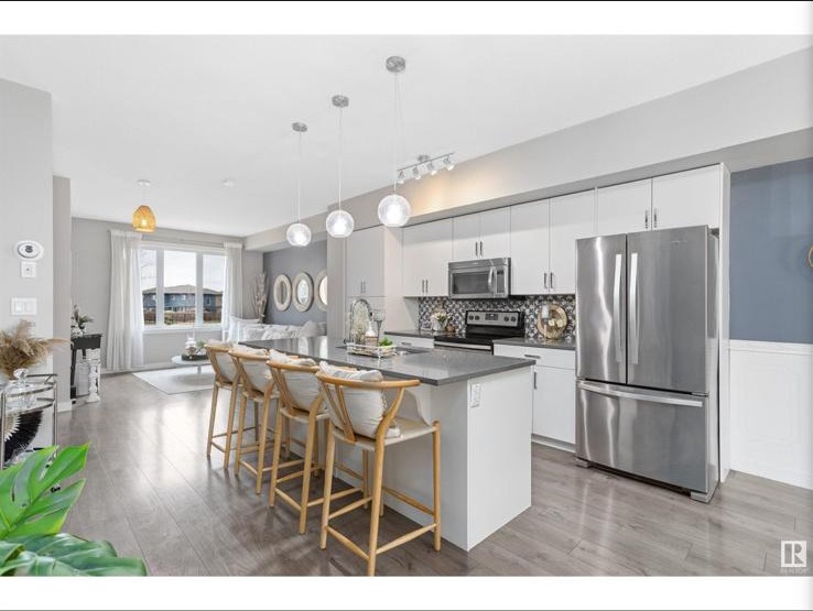 Open-concept kitchen looking through to bright living room