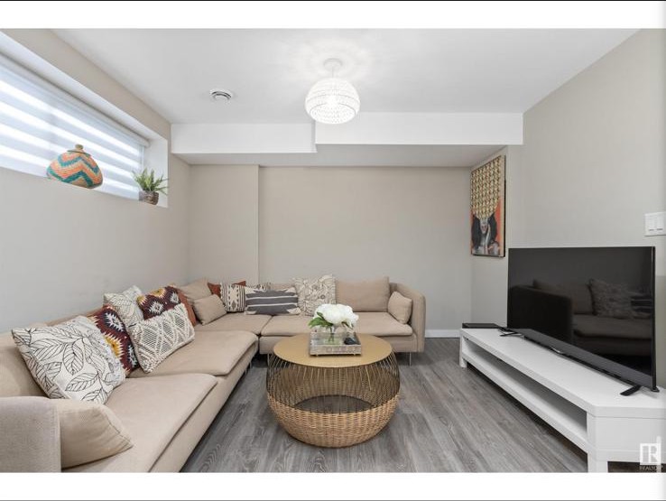 Lower-level lounge with neutral sectional and patterned pillows