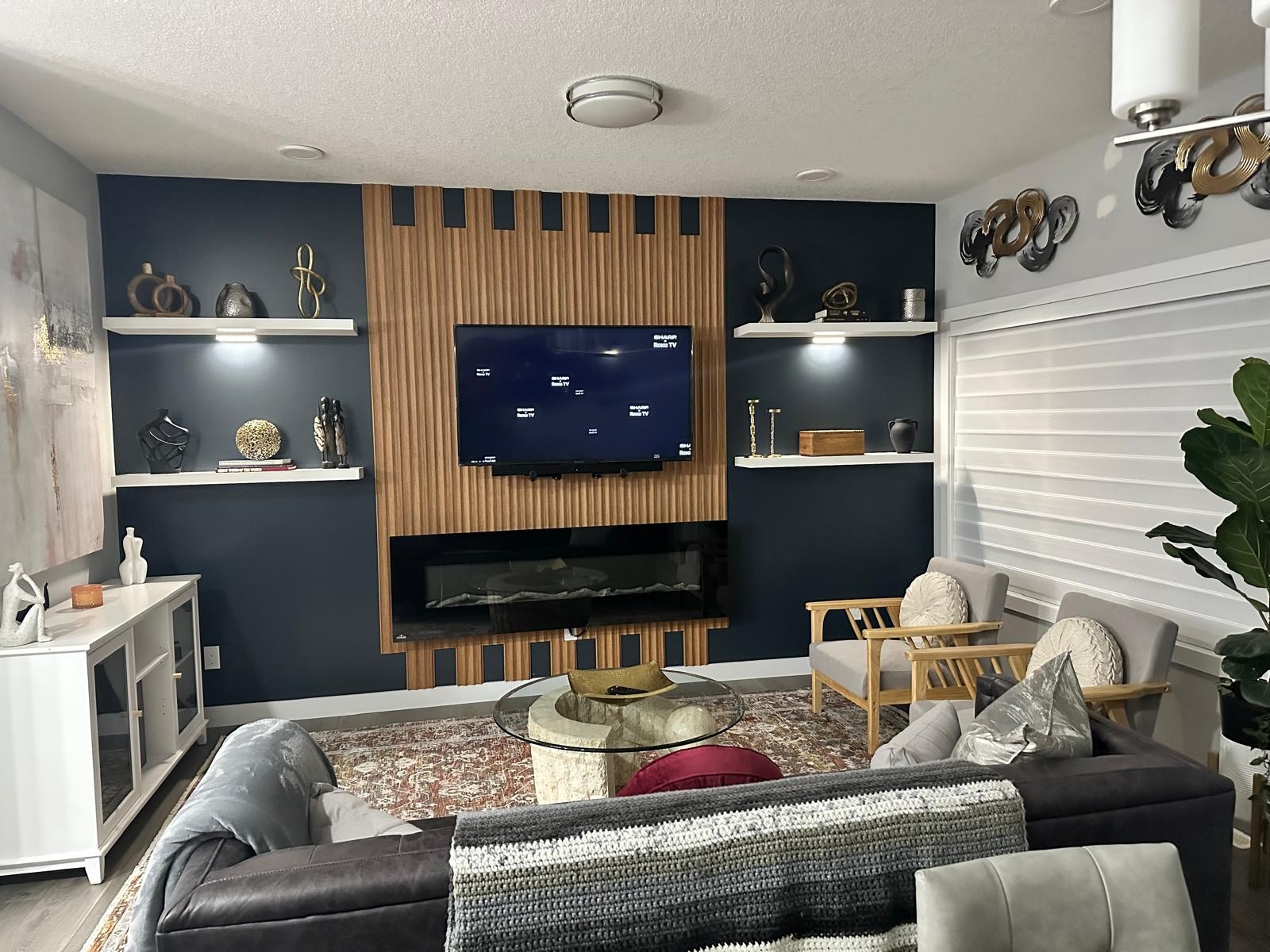 Closer view of navy media wall with styled floating shelves