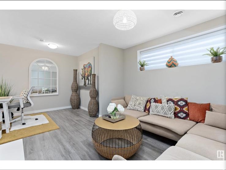 Wide view of lower-level lounge with wicker coffee table