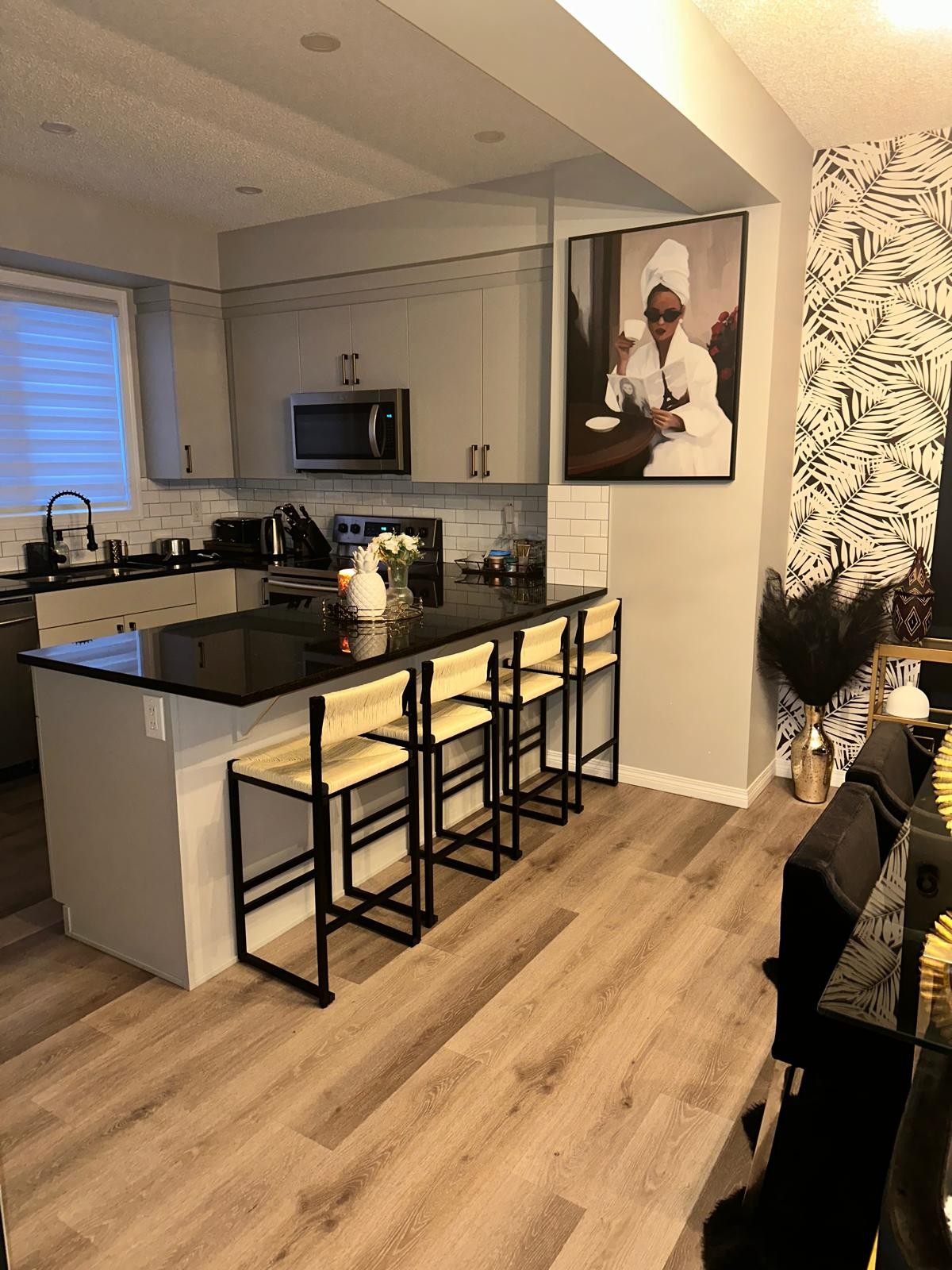 Edmonton kitchen with woven bar stools, statement art and palm wallpaper