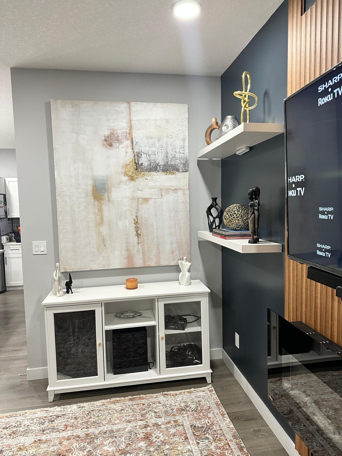 Abstract painting above white sideboard beside the media wall