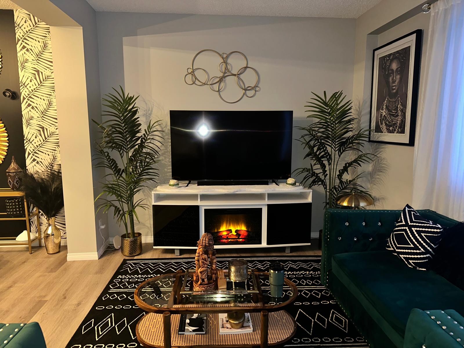 Styled TV media wall with palms and gold ring sculpture